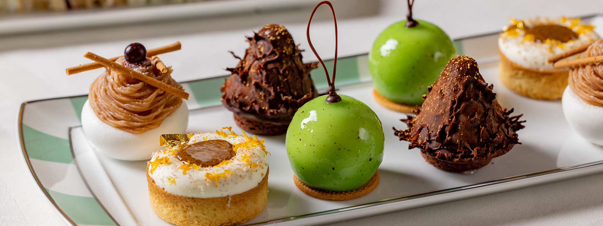 Assortment of cakes of different shapes and colours on a plate.