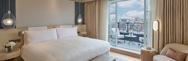 Large bed in Claridge's Terrace Suite bedroom with open double doors to terrace